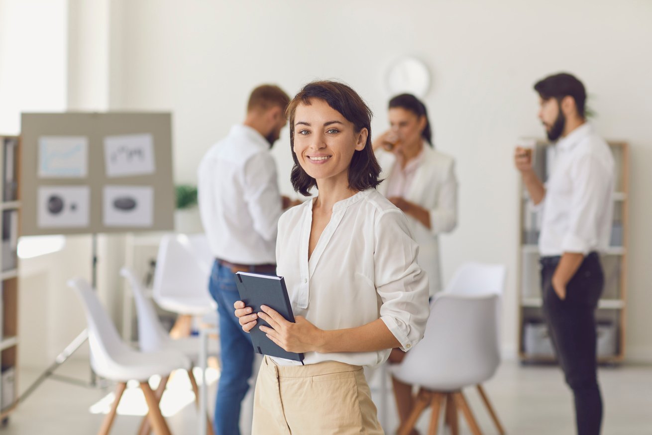 Happy Successful Businesswoman or Company Leader Standing in Office Looking at Camera and Smiling